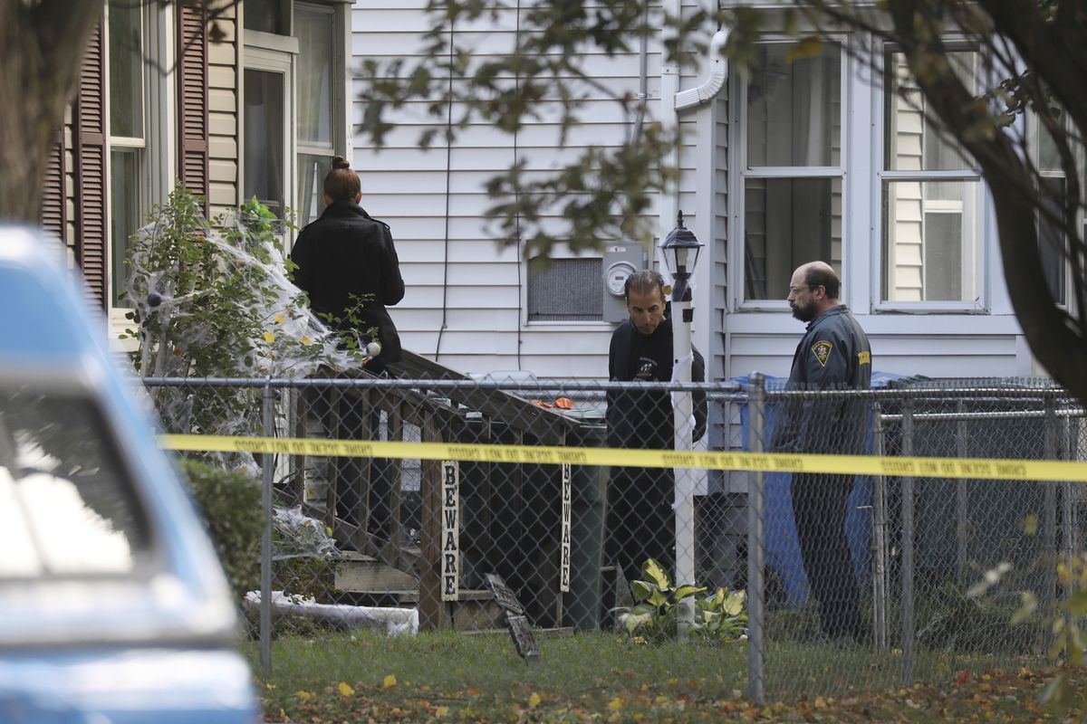 Rochester police look over the area of a home after a fatal shooting at a backyard house party, Saturday, Sept. 19, 2020, in Rochester, N.Y. Police in Rochester, say several people died and others were wounded by gunfire at a backyard party early Saturday.  (Tina MacIntyre-Yee)