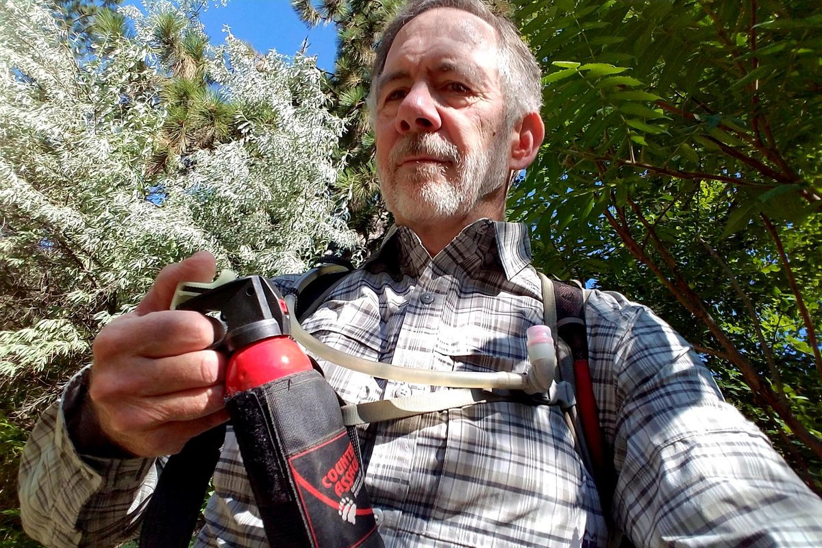 Author Rich Landers holds a canister of bear spray while on a hike. (Rich Landers / The Spokesman-Review)