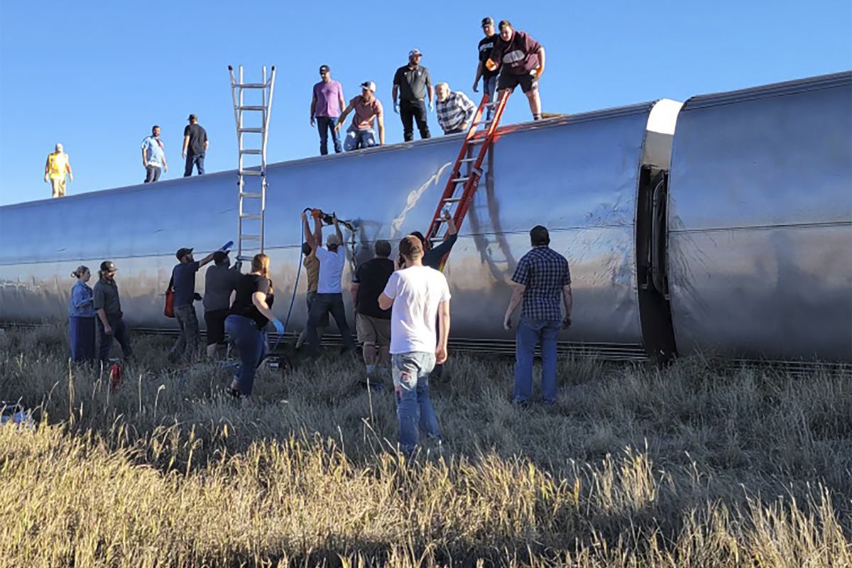 In this photo provided by Kimberly Fossen people work at the scene of an Amtrak train derailment on Saturday, Sept. 25, 2021, in north-central Montana. Multiple people were injured when the train that runs between Seattle and Chicago derailed Saturday, the train agency said.  (Kimberly Fossen)