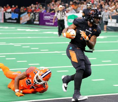 Arizona Rattlers running back Darrell Monroe runs into the end zone past Spokane Shock defensive back Darius Thomas on Saturday night at Phoenix Suns Arena in Arizona.   (Courtesy of Matt Hinshaw,)