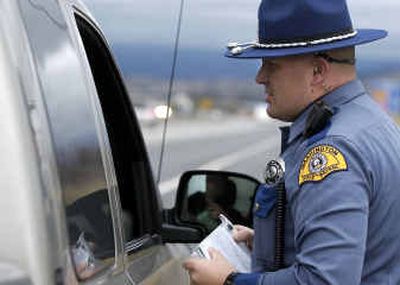 
Washington State Patrol Trooper Scott Lasher hands out a traffic infraction ticket to a driver headed east on I-90 just past Sullivan in the Spokane Valley on Wednesday. 
 (Liz Kishimoto / The Spokesman-Review)