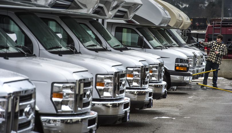 Thomas Busse, of Freedom RV, hoses down Class C recreation vehicles on Wednesday before the start  of the 30th annual Inland Northwest RV Show and Sale at the Spokane County Fair & Expo Center. (Dan Pelle / The Spokesman-Review)