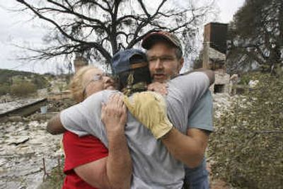 
Thomas Goodlett hugs neighbors Judi Tyrrell and John Moros after they return to see their destroyed home in Ramona, Calif., on Saturday. Associated Press
 (Associated Press / The Spokesman-Review)