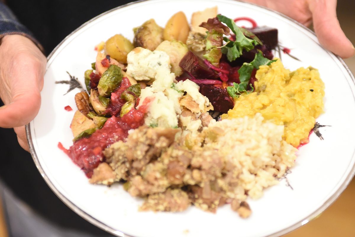A diner shows off a full plate at the monthly vegan potluck organized by Inland Northwest Vegans, a group of vegans who meet for food, recipe sharing, health information and fun once a month at the Spokane Woman’s Club. On the plate are holiday staples, such as roasted or mashed potatoes, stuffing, beets and Brussels sprouts. (Jesse Tinsley / The Spokesman-Review)
