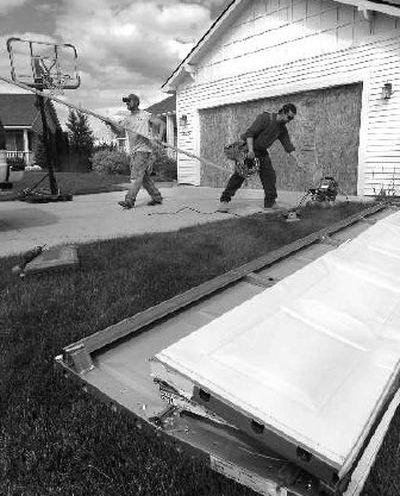 
Luke Prochnow, left, and David Jacobs pack up Friday after boarding up a garage on East Cataldo Court. 
 (Ingrid Lindemann / The Spokesman-Review)