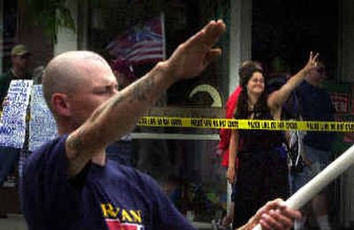 
Jerald O'Brien, 25, of Coeur d'Alene, gives a Nazi salute while Destiny Turner, 22, offers a peace sign during the Aryan Nations march in Coeur d'Alene on Saturday. 
 (Jed Conklin / The Spokesman-Review)