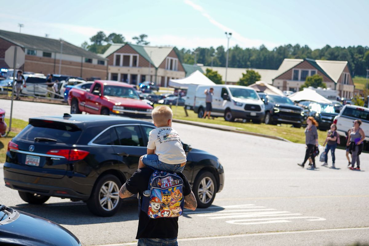 WINDER, GEORGIA - SEPTEMBER 4: A father walks by Apalachee High School with his son on his shoulders as after a school shooting on September 4, 2024 in Winder, Georgia. Multiple fatalities and injuries have been reported and a suspect is in custody according to authorities. (Photo by Megan Varner/Getty Images)S  (Megan Varner)