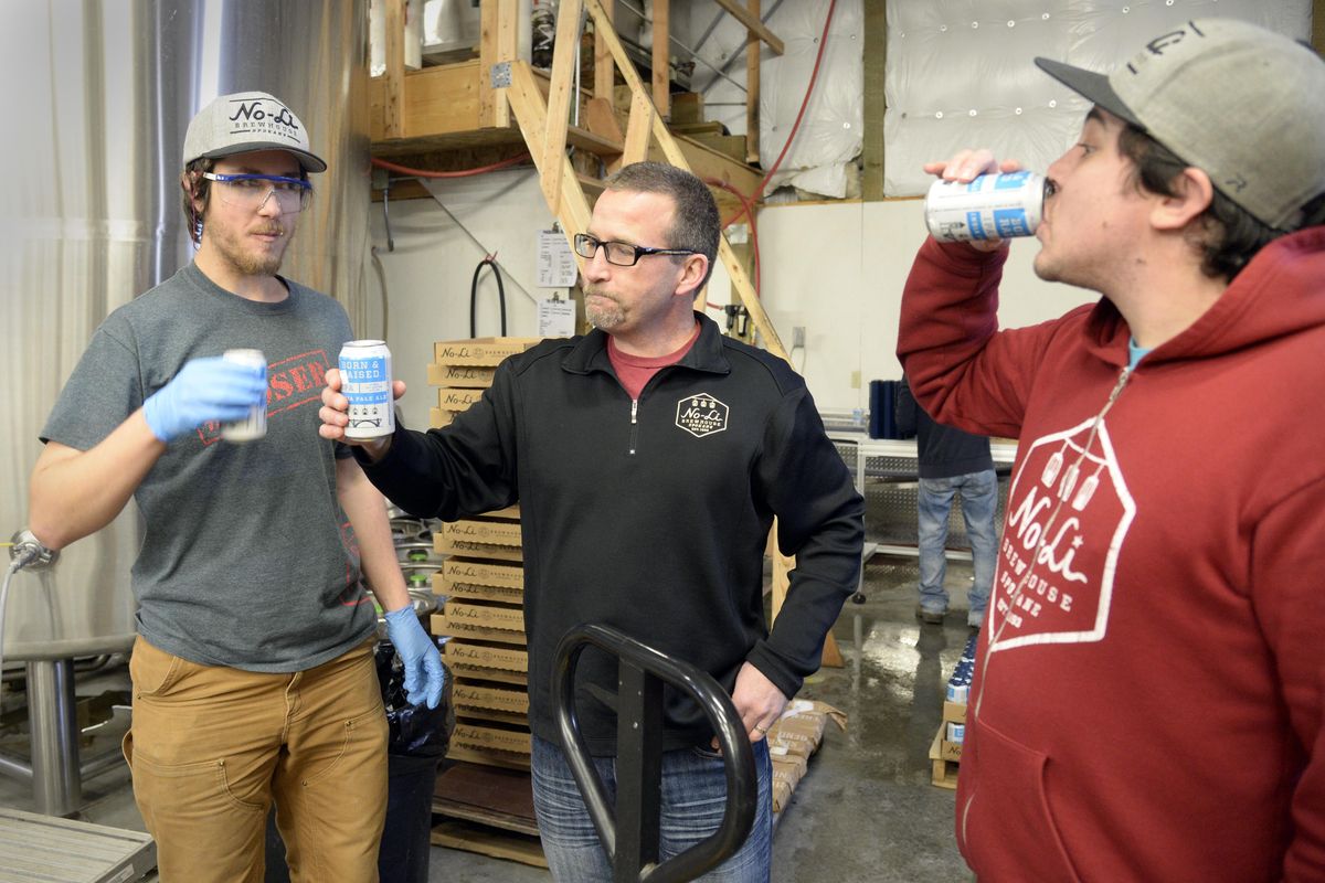 No-Li Brewhouse lead brewer Carey Fristoe, left, owner John Bryant and brewery operations manager Damon Scott, right, take a taste of their Born & Raised IPA as it