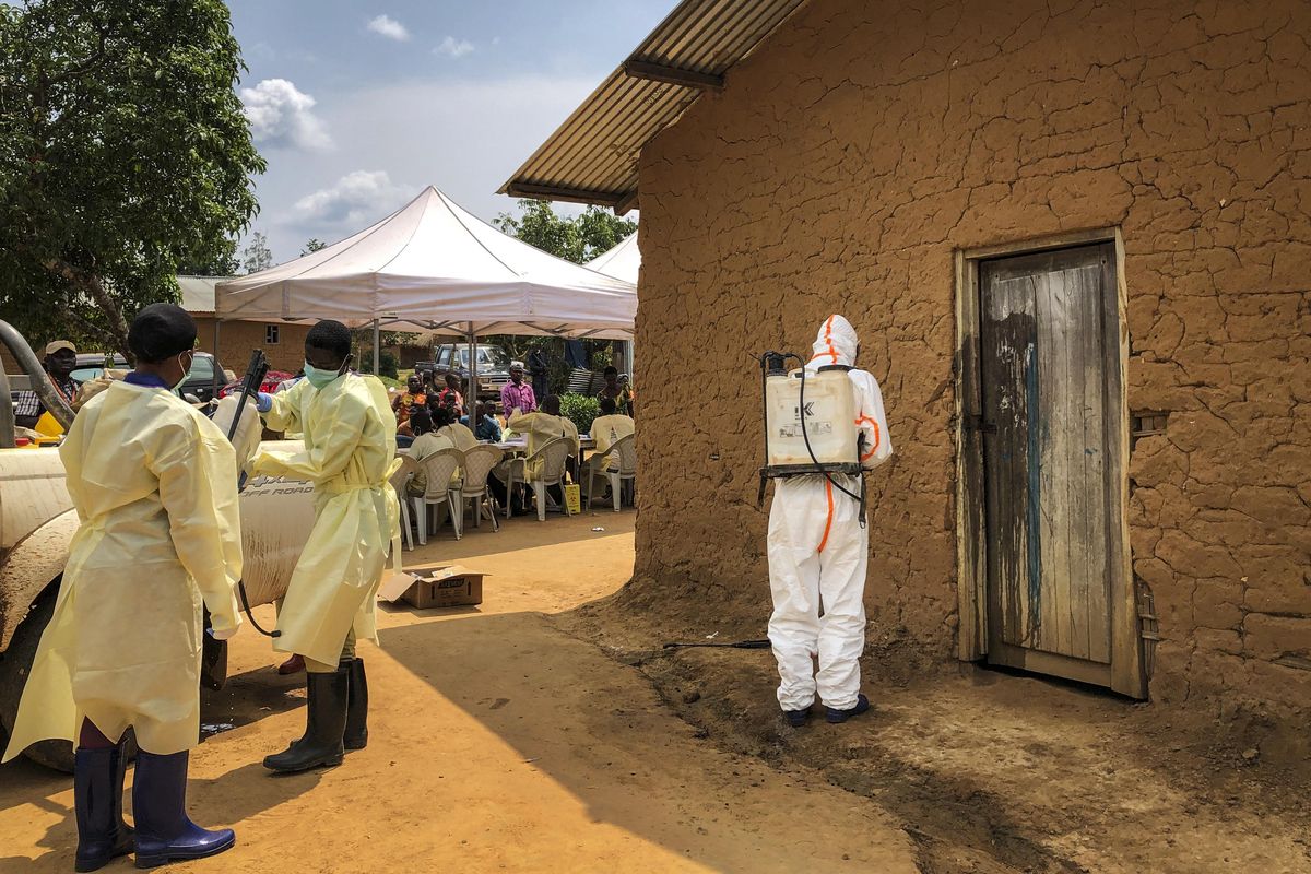 A worker from the World Health Organization decontaminates the doorway of a house on a plot where two cases of Ebola were found, in the village of Mabalako, in eastern Congo on Monday, June 17, 2019. Health officials in eastern Congo have begun offering vaccinations to all residents in the hotspot of Mabalako whereas previous efforts had only targeted known contacts or those considered to be at high risk. (Al-hadji Kudra Maliro / Associated Press)