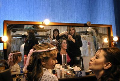 
Jessica Shaeffer, a model for the Bridal Festival fashion show, shares a laugh with Zi Spa stylist Nathlaie Fernimen, reflected in mirror,  as model Jill Moss tries to get model Kourtney O'Neal, 5, to pucker up for makeup Saturday at the Spokane Convention Center. 
 (Jed Conklin / The Spokesman-Review)