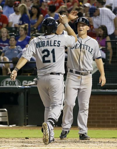 Seattle Mariners' Kendrys Morales (21) is met at the plate by Kyle Seager, right, after hitting a two-run home run off Texas Rangers relief pitcher Shawn Tolleson that also scored Seager in the sixth inning on Friday. (Associated Press)