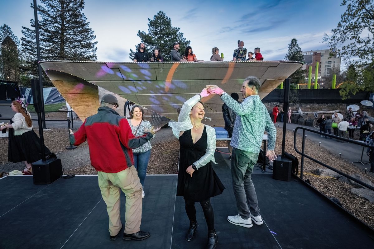 Amanda Hansen and her friend Jim Palm, on right, dance to ’70s music in front of Riverfront Park art piece Stepwell, which has been transformed into a speakeasy as part of Expo ’74 celebration.  (COLIN MULVANY/The Spokesman-Review)