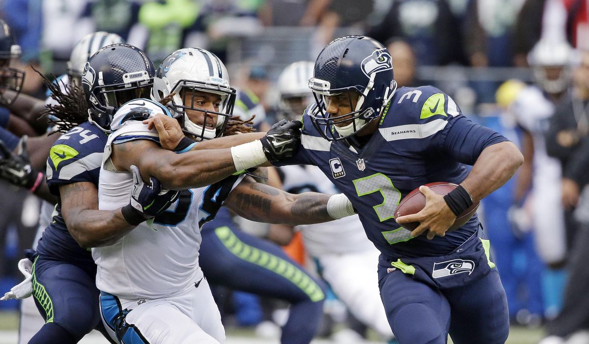 Seattle Seahawks quarterback Russell Wilson, right, tries to fend off Carolina Panthers outside linebacker Shaq Thompson, left, in the second half of the Panthers’ 27-23 victory in Seattle in October. (Elaine Thompson / Associated Press)