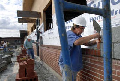 
Steve Oden of Alex Butters Masonry taps a brick into position on the east exterior wall of the new Sacajawea Middle School library in Spokane on Wednesday. 
 (Dan Pelle / The Spokesman-Review)