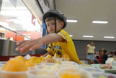 Kalani Porter, 8, chooses a fruit cup in the breakfast line Friday at Seltice Elementary School, one of the sites serving free meals to children as part of a federal program. Any child under 18 may eat a free breakfast or lunch at several locations in Post Falls and Coeur d'Alene, and adults can eat for a low price.
(Photos by JESSE TINSLEY / The Spokesman-Review)