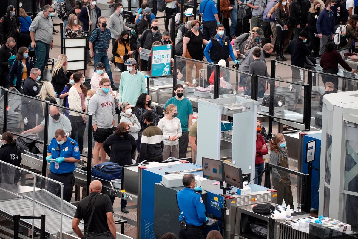 Travelers line up at Denver International Airport on Nov. 23. President Joe Biden on Monday signed an executive order aimed at saving Americans time while using some federal services.   (David Zalubowski)