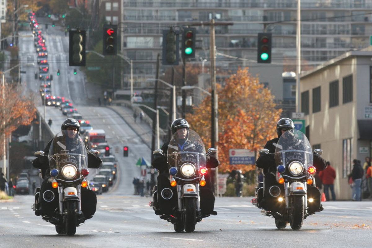 A procession of hundreds of police and fire department vehicles winds from the University of Washington to KeyArena for a memorial for slain Seattle police Officer Timothy Brenton in Seattle on Friday, Nov. 6, 2009. (Barry Fitzsimmons / Seattle Times)