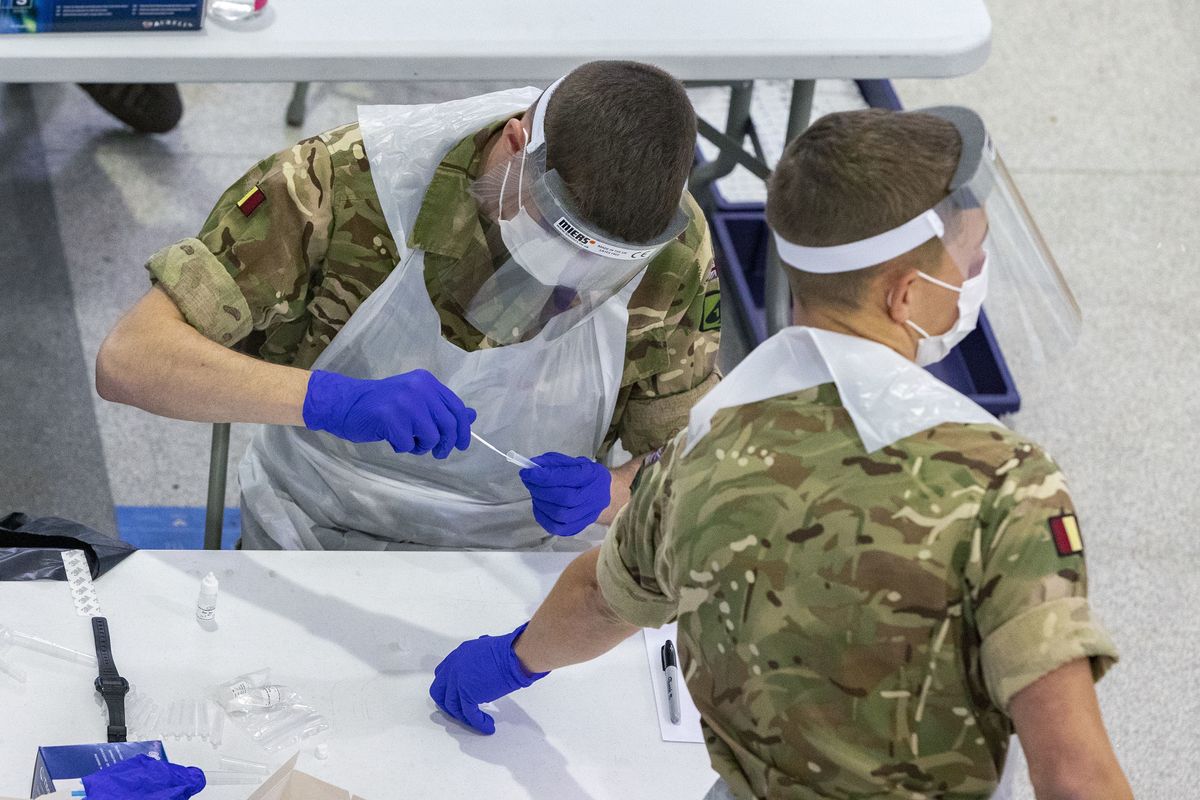 Soldiers carry out mass coronavirus testing, set up at a marketplace in Liverpool, England, during the four-week national lockdown to curb the spread of coronavirus in England, Wednesday Nov. 11, 2020. Everyone in Liverpool city, are being encouraged to be tested for COVID-19, even if they are not displaying symptoms, as authorities continue a mass testing pilot scheme to suppress the coronavirus.  (Peter Byrne)