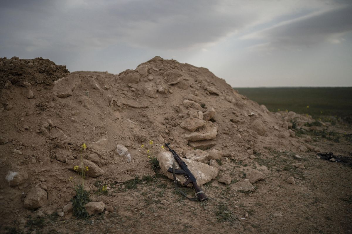 An AK-47 rifle, belonging to a U.S.-backed Syrian Democratic Forces fighter, rests on a rock on a hill in the desert outside the village of Baghouz, Syria, Thursday, Feb. 14, 2019. U.S.-backed Syrian forces are clearing two villages in eastern Syria of remaining Islamic State militants who are hiding among the local population, and detaining others attempting to flee with the civilians, the U.S.-led coalition said Thursday. (Felipe Dana / Associated Press)