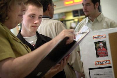 
Rogers High School sophomore Daymian Lockman watches as Karen Erp, from Washington State University Spokane's human resources office, looks at his credentials at NorthTown Mall on Wednesday. Lockman was looking for a summer job in carpentry or mowing lawns. 
 (Holly Pickett / The Spokesman-Review)