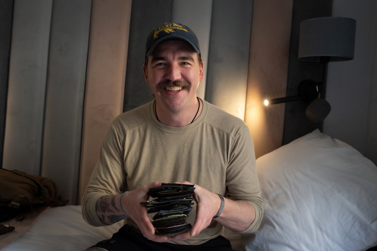 Chris Warren shows off patches he received from Ukrainian military units after returning from Ukraine on April 27. Warren spent nearly two months in Ukraine fighting for the Ukrainian military.  (Eli Francovich/The Spokesman-Review)