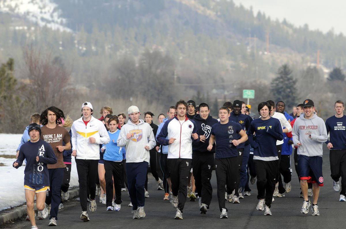 Members of the Community Colleges of Spokane cross country and track teams run along the Spokane River on Friday afternoon. They ran in memory of coach Erik Anderson, who was killed in an accident on the Spokane Community College campus Thursday.  (Jesse Tinsley / The Spokesman-Review)
