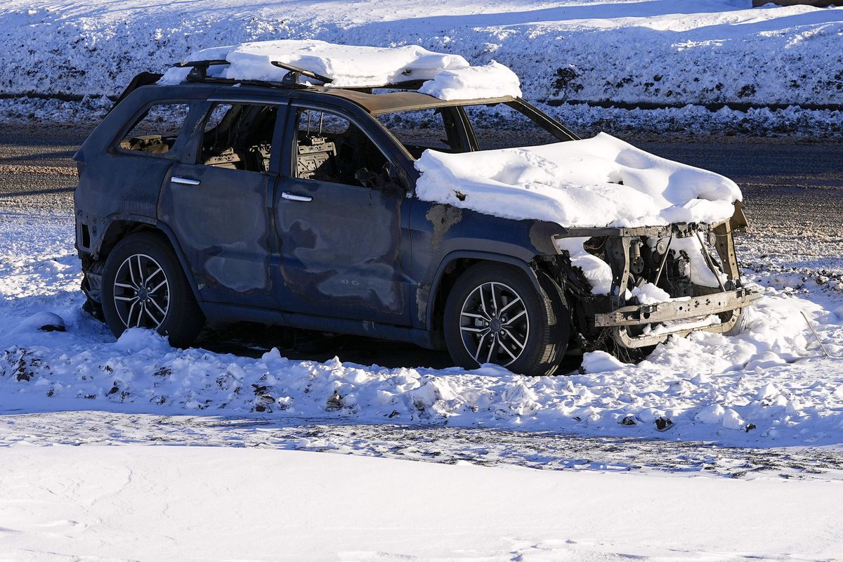 Snow covers the burned remains of a car after wildfires ravaged the area Sunday, Jan. 2, 2022, in Superior, Colo. Investigators are still trying to determine what sparked a massive fire in a suburban area near Denver that burned neighborhoods to the ground and destroyed nearly 1,000 homes and other buildings.  (Jack Dempsey)