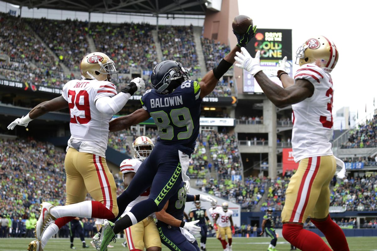 A pass intended for Seattle Seahawks wide receiver Doug Baldwin (89) falls incomplete as San Francisco’s Dontae Johnson, right, and Jaquiski Tartt, left, defend in the first half of an NFL football game, Sunday, Sept. 17, 2017, in Seattle. (John Froschauer / Associated Press)