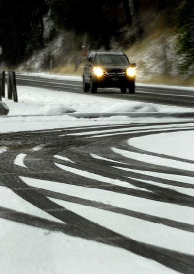 
A motorist drives on icy Lake Coeur d'Alene Drive in Coeur d'Alene on Monday. 
 (Kathy Plonka / The Spokesman-Review)