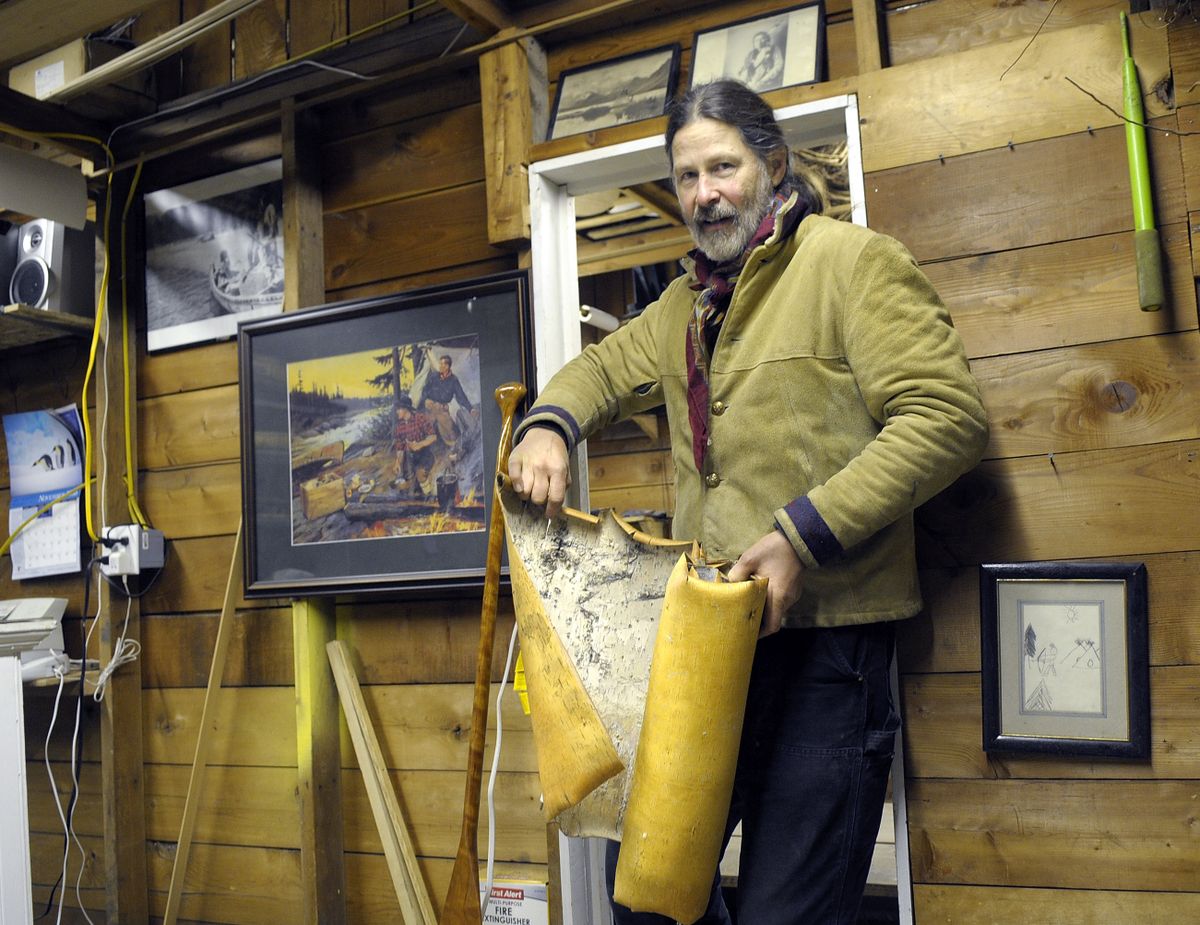 John Lindman opens a roll of birch bark that he recently received at his north Spokane Washington business The Bark Canoe Store. (Christopher Anderson / The Spokesman-Review)