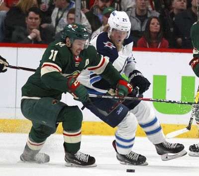 Minnesota Wild left wing Zach Parise (11) battles with Winnipeg Jets right wing Patrik Laine (29) in the first period of Game 3 of an NHL first-round hockey playoff series Sunday, April 15, 2018, in St. Paul, Minn. The Wild won the game 6-2 but trail the Jets 2-1 in the series. (Andy Clayton-King / Associated Press)