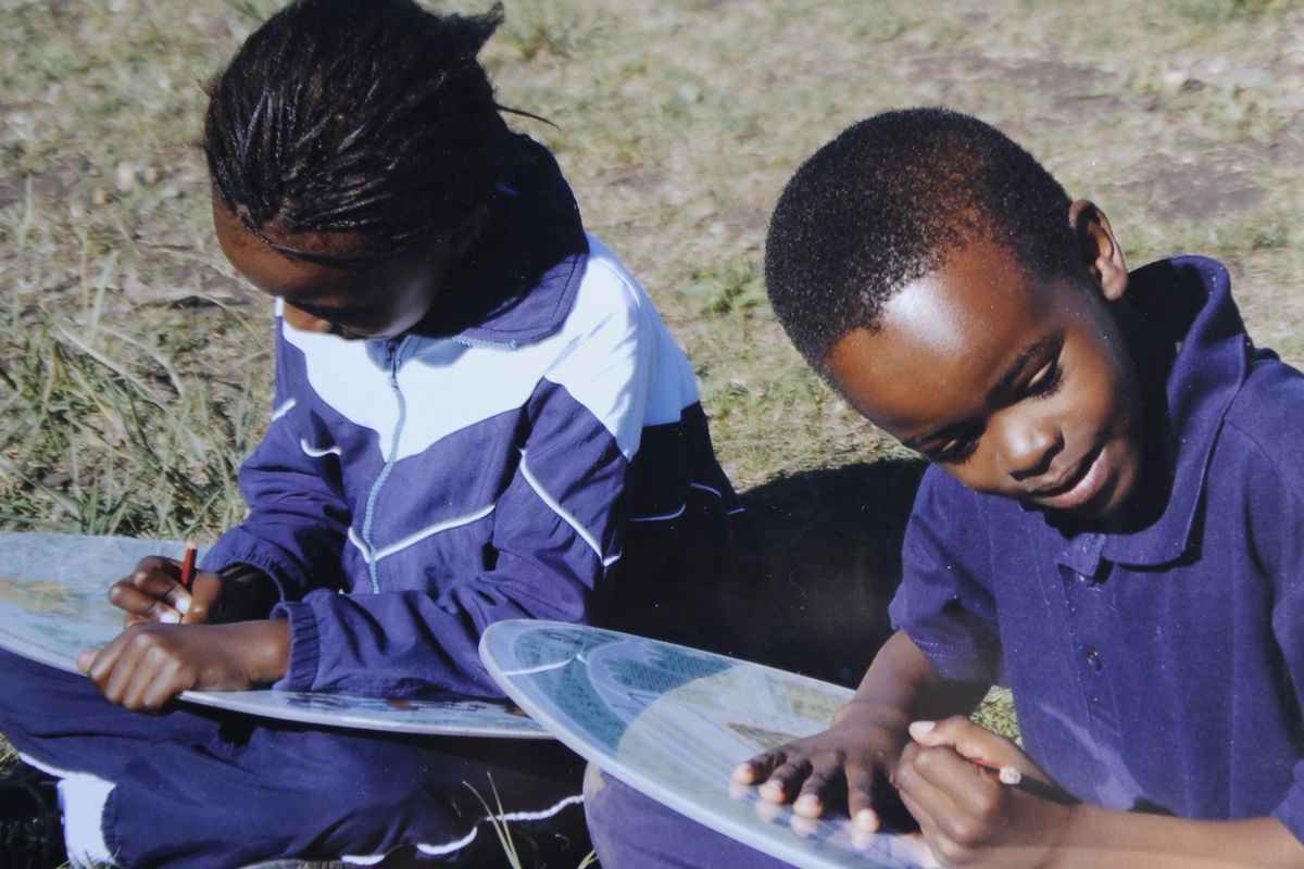 Students in the country of Malawi use a prototype of the Portable Academic LapDesk. (Colin Mulvany / The Spokesman-Review)