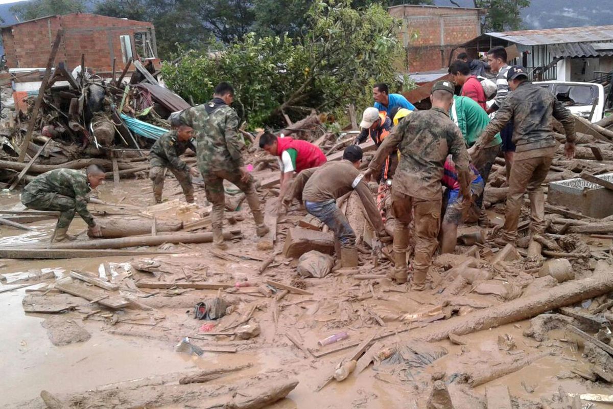Soldiers and residents work together in rescue efforts in Mocoa, Colombia, Saturday, after an avalanche of water from an overflowing river swept through the city as people slept. The incident triggered by intense rains left at least 150 people dead in Mocoa, located near Colombia's border with Ecuador. (Colombian Army Photo via Associated Press)
