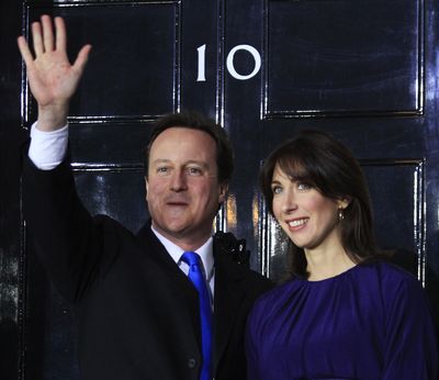 Britain’s new Prime Minister David Cameron, accompanied by his wife, Samantha, arrives at No. 10 Downing Street on Tuesday.  (Associated Press)