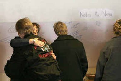 
Friends of Red Lake High teacher Neva Rogers console each other near a wall with messages of remembrance for Rogers during funeral services Monday. 
 (Associated Press / The Spokesman-Review)