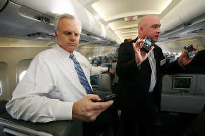David Neeleman, left, founder and chairman of JetBlue, and Eric Ritter, a director with Research in Motion, use their Blackberry devices during a media preview flight aboard