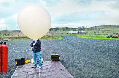 
University of Idaho electrical engineering sophomore Justin Schlee holds a weather balloon Friday while it is inflated with gas. The NASA-sponsored balloon, designed and launched by UI students, carried a payload of electronic equipment and cameras up through the jet stream. 
 (Brian Plonka / The Spokesman-Review)