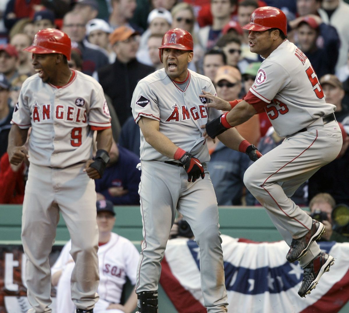 Los Angeles’ Bobby Abreu, right, celebrates with Chone Figgins, left, and Kendry Morales after Abreu and Figgins scored in the ninth inning for a 7-6 lead. (Associated Press / The Spokesman-Review)