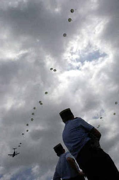 
Members of the French Gendarmerie Nationale watch as American paratroopers drop near St. Mere Eglise, France, on Saturday. 
 (Associated Press / The Spokesman-Review)
