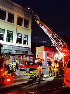 Tired firefighters regroup after battling a blaze in a three-story building at the northwest corner of Sherman Avenue and Fourth Street in Coeur d'Alene. (JUDITH YANCEY/CDA PRESS)