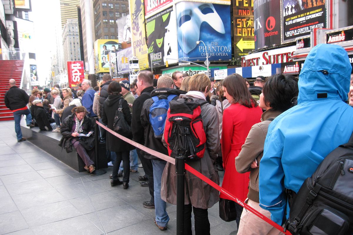 A line of ticket-buyers wait at the TKTS booth, which sells discount tickets to Broadway shows,  in New York