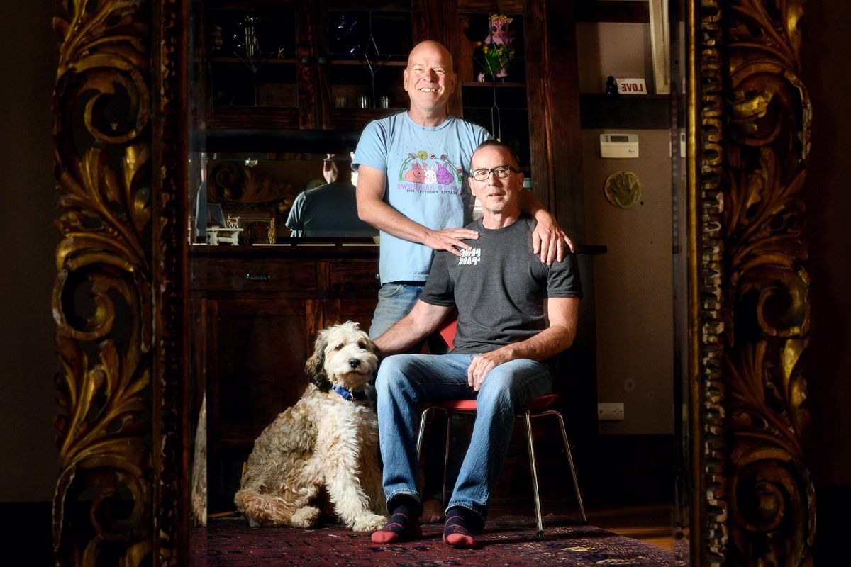 Andrew Whitver (standing) photographed with his partner Kevin Brannaman and their dog Monroe at their South Hill home, is organizing the Queer Art Walk, a First Friday event timed to coincide with Pride month and the 50th anniversary of the Stonewall riots. (Colin Mulvany / The Spokesman-Review)