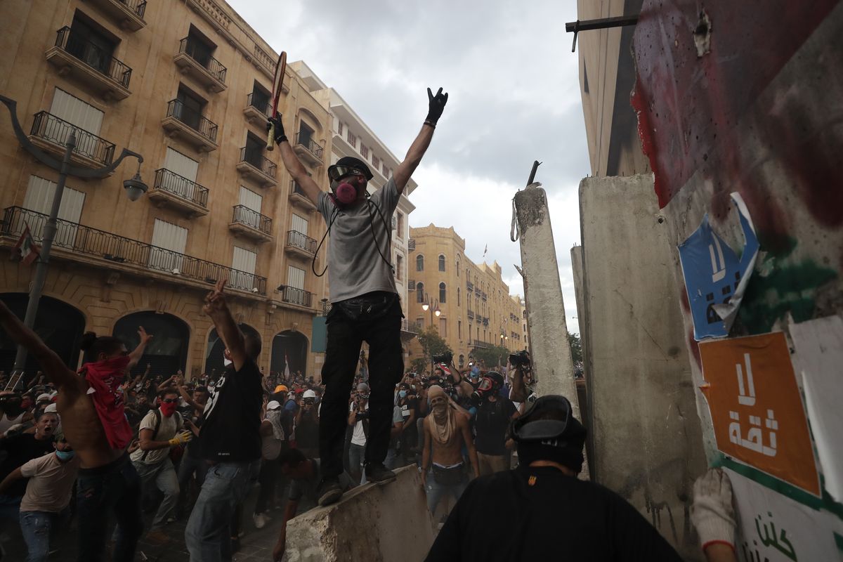 Protesters celebrate after removing a concrete slab from a barrier to open a road leading to the parliament building during demonstrations following Tuesday