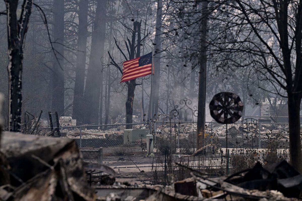 An American Flag blows amid the rubble of a destroyed home on Saturday, Aug. 19, 2023, in Medical Lake.  (Tyler Tjomsland/The Spokesman-Review)
