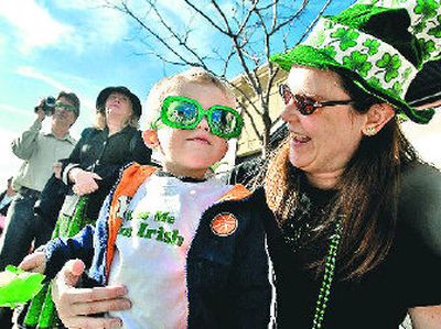 
Alex Green, 20 months, and his mother, Brenda Green, watch the St. Patrick's Day Parade in downtown Coeur d'Alene on Saturday. 
 (Jesse Tinsley / The Spokesman-Review)