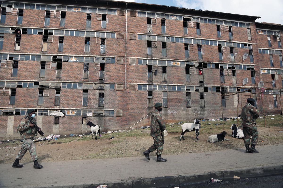 South African Defence Force soldiers on patrol alongside the male single sex hostels in Alexandra Township, north of Johannesburg, Thursday, July 15 2021. The army has begun deploying 25,000 troops to assist police in quelling the weeklong riots and violence sparked by the imprisonment of former President Jacob Zuma.  (STR)