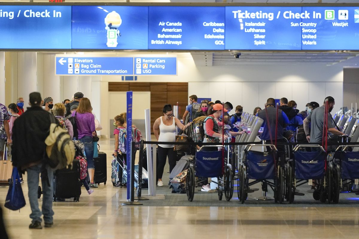 Holiday travelers check in at kiosks near an airline counter at Orlando International Airport Tuesday, Nov. 24, 2020, in Orlando, Fla.  (John Raoux)