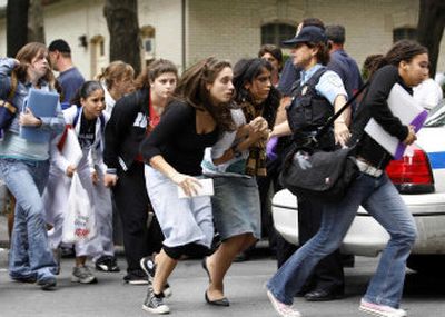 
Students run from Dawson College in Montreal, Canada, on Wednesday after reports of a gunman in the building. At least 20 people were wounded before the gunman was killed; one later died.
 (Associated Press photos / The Spokesman-Review)