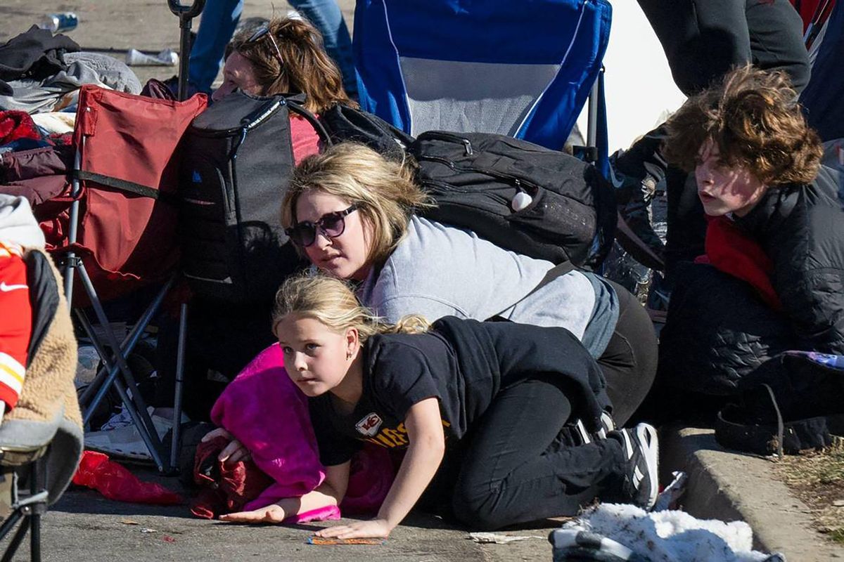 Kansas City Chiefs fans take cover after shots were fired at the conclusion of the Super Bowl rally at Union Station on Wednesday in Kansas City, Mo. More than 20 people were shot, including one fatally.  (Tammy Ljungblad)