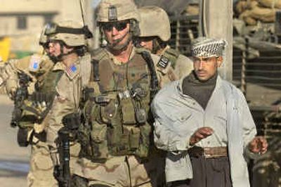 
U.S. Army Lt. Col. Eric Kurilla holds an Iraqi man for questioning Saturday in Mosul. Two days of rebel attacks killed at least 42 Iraqis.
 (Associated Press / The Spokesman-Review)